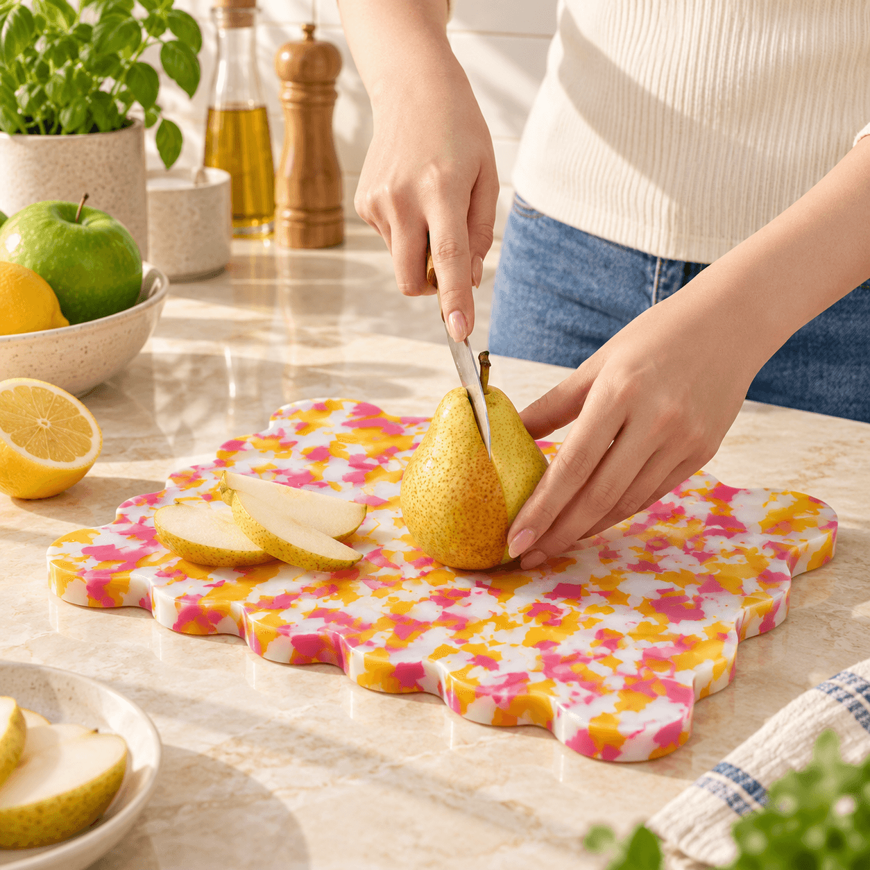 Slicing a pear on a pink and yellow speckled Kiyomi board, lifestyle kitchen photo