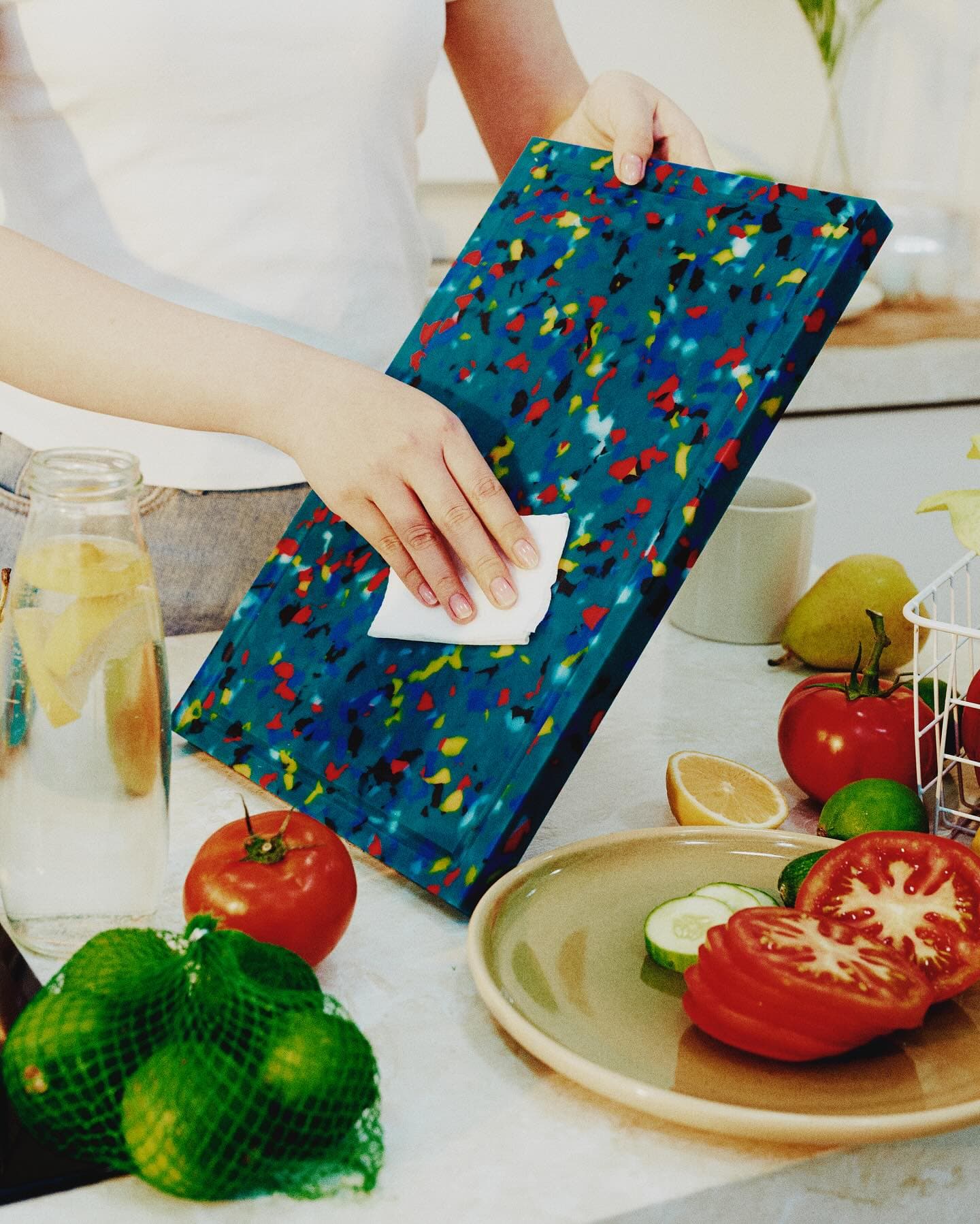 Wiping a terrazzo cutting board in use, lifestyle detail