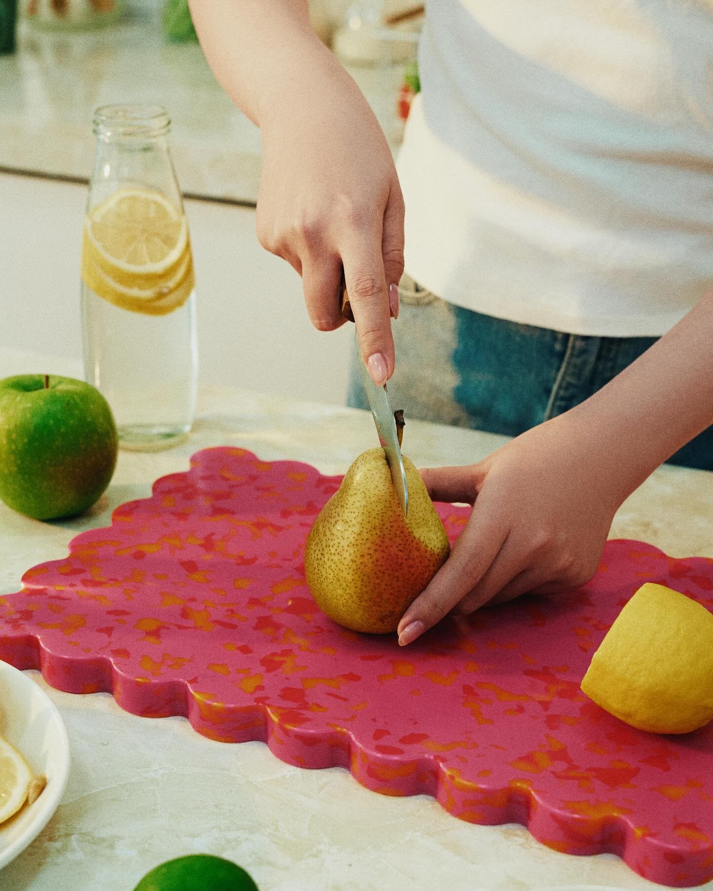 Sliced pear on a pink terrazzo board, styled food photo