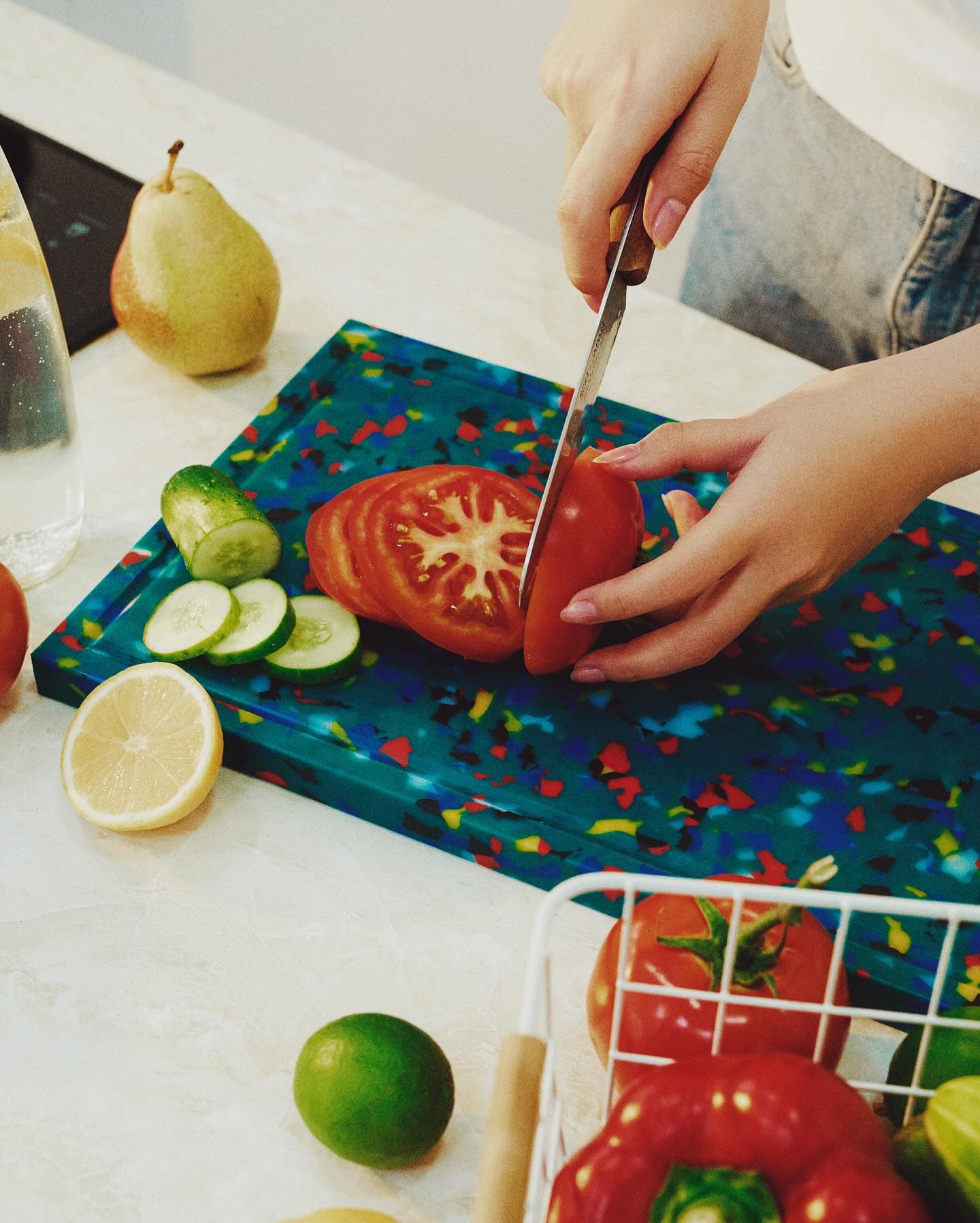 Tomato sliced on a blue terrazzo cutting board