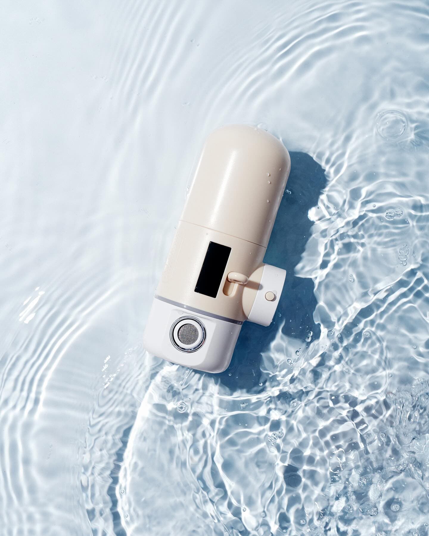 Oshin faucet water filter floating in water, creative product shot
