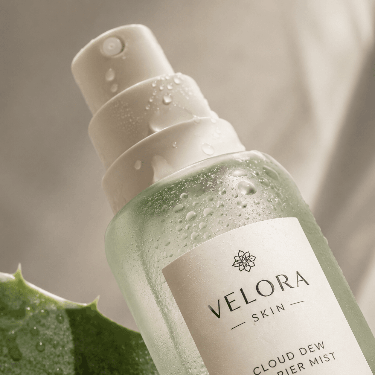 Macro close-up of the Velora Skin mist nozzle with water droplets and aloe